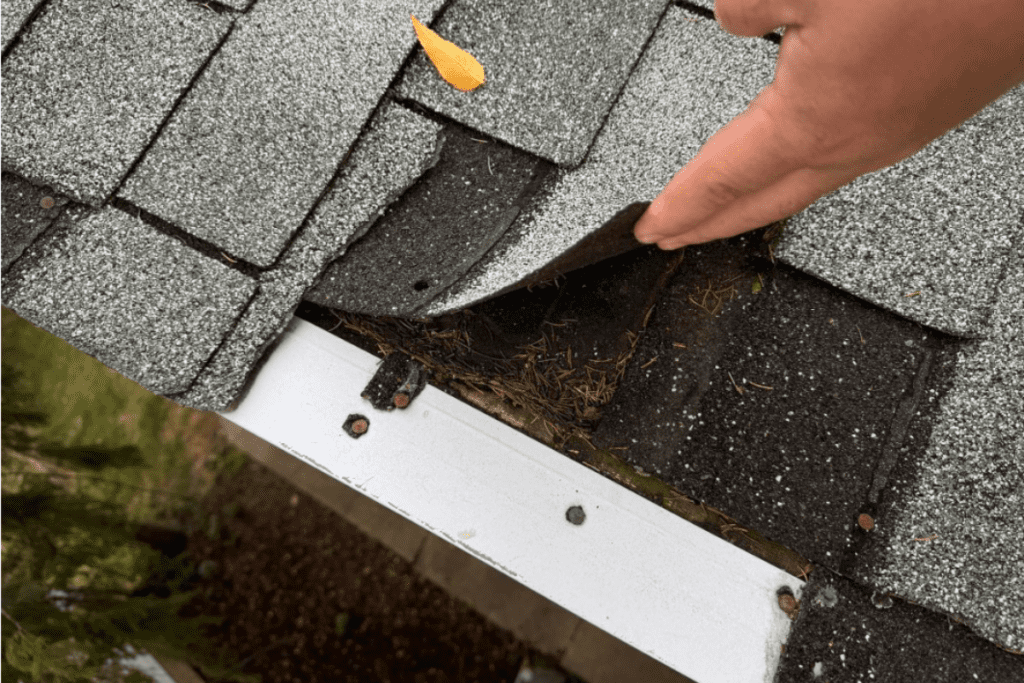 A roofer checking shingles for Residential Roof Inspection